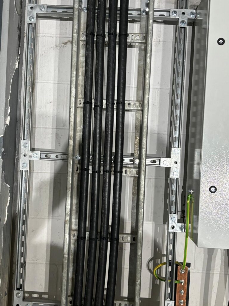 Three-phase distribution board internals with the busbar chamber and sub-main cables