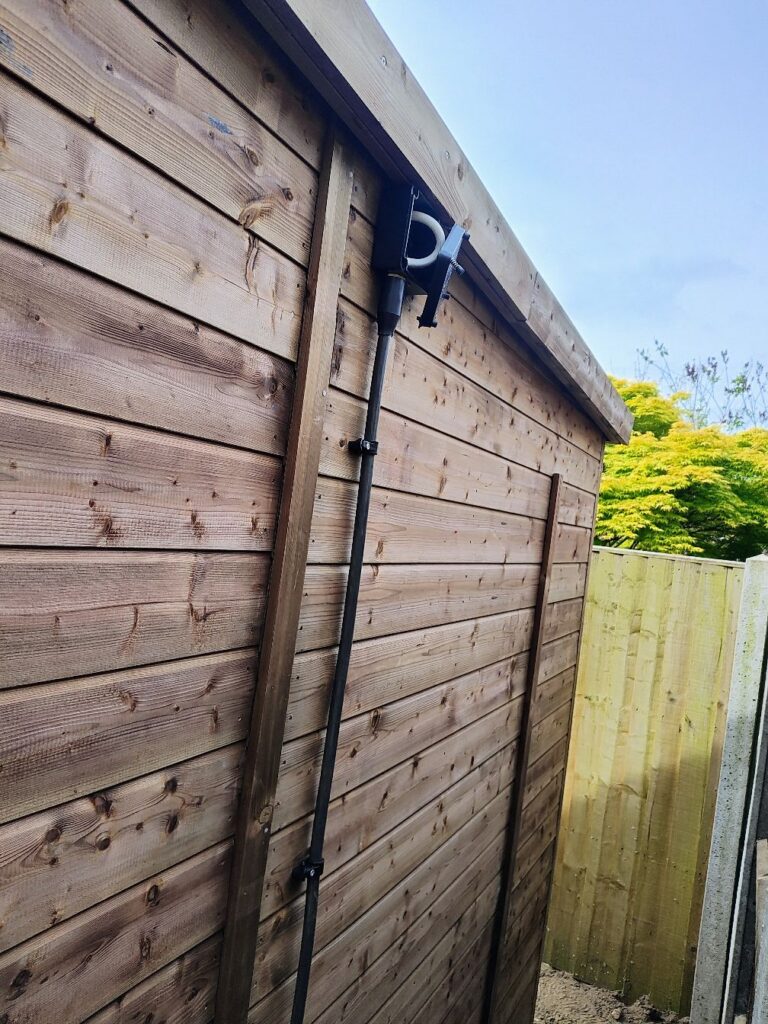 Protected supply run up the fence line to a garden bar in Norwich