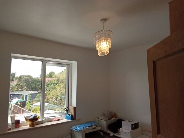 Rewired pendant lighting in a bedroom overlooking the garden