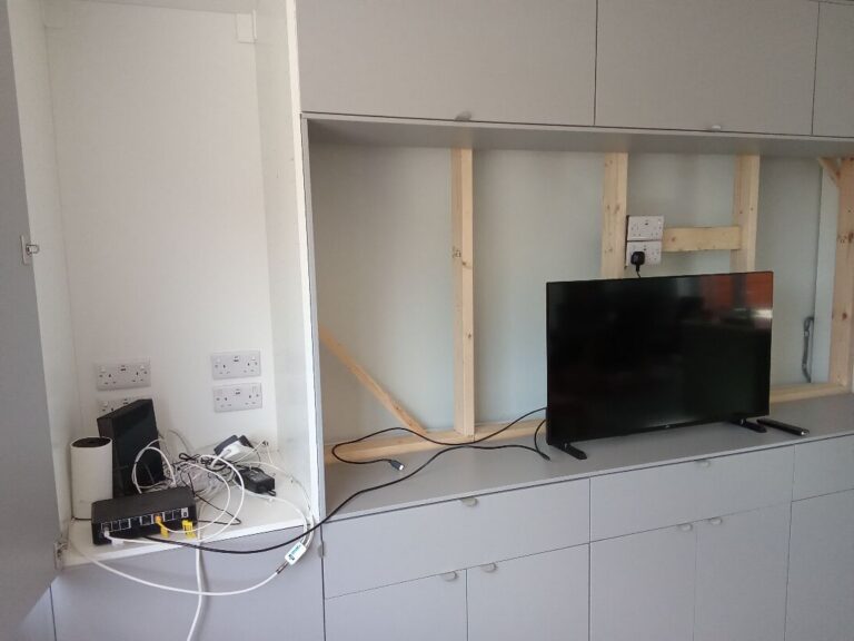 Finished media wall with concealed sockets and data outlets